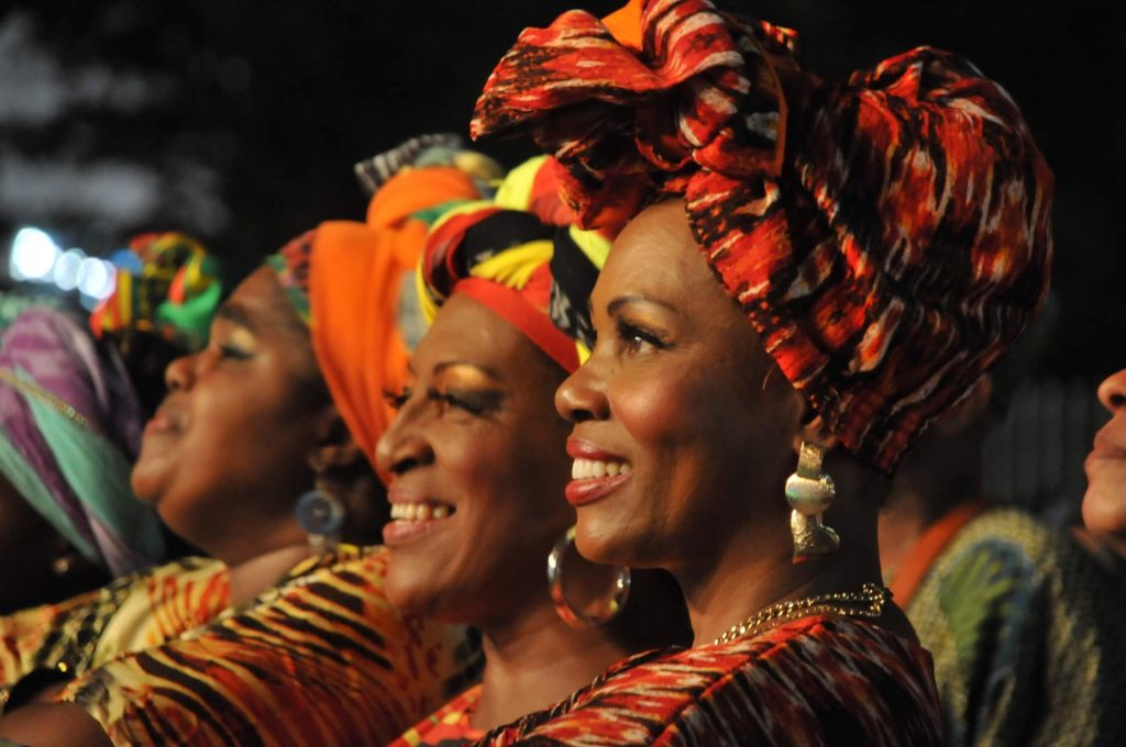 lindas mujeres afros vistiendo turbantes grandes y sonriendo